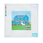 A needlepoint canvas featuring a pixelated blue house on a green lawn with the word 'GILMORE' in front, shown on a white grid background with a color palette strip on the left and the brand name 'needle mouth' in the bottom right corner.