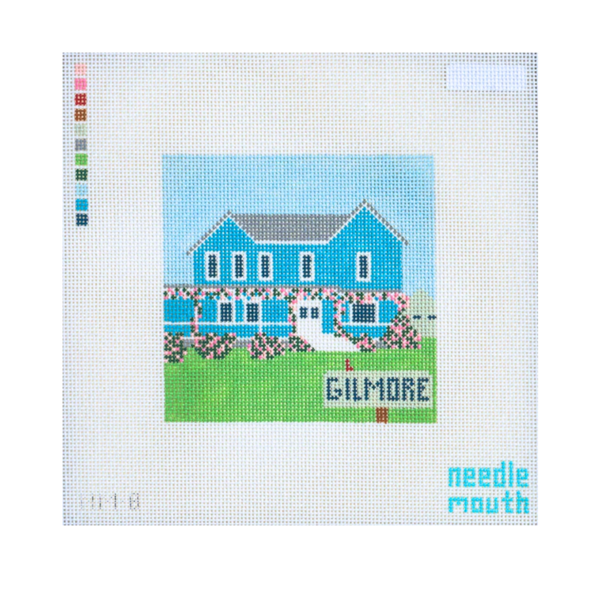 A needlepoint canvas featuring a pixelated blue house on a green lawn with the word 'GILMORE' in front, shown on a white grid background with a color palette strip on the left and the brand name 'needle mouth' in the bottom right corner.