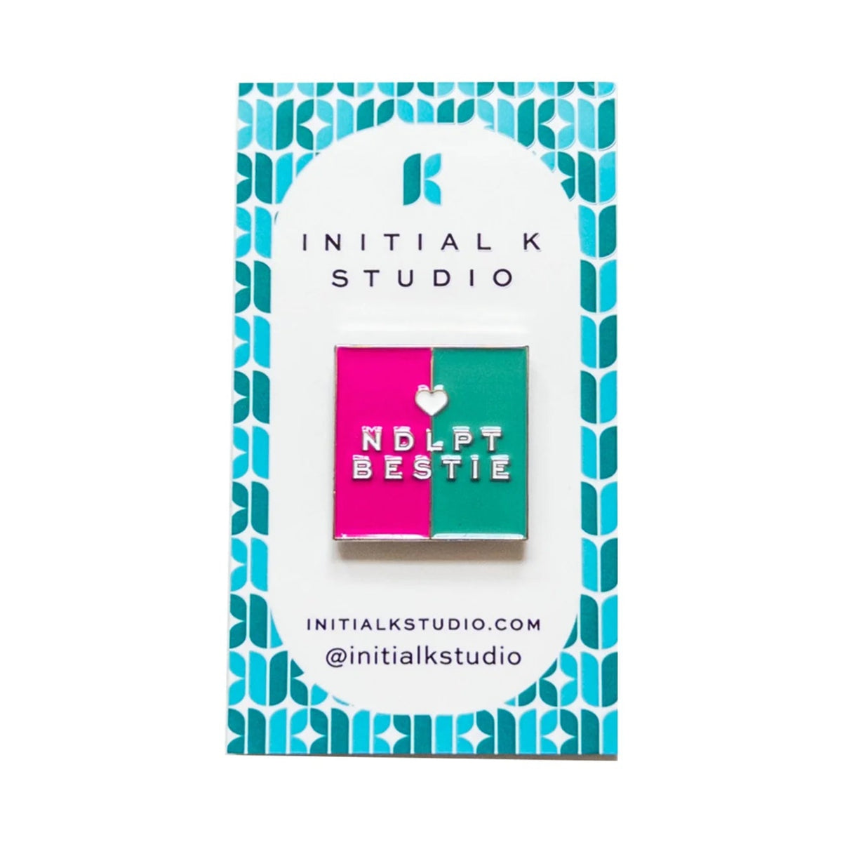 A square enamel pin by Initial K Studio featuring a split design of hot pink and teal with the text 'NDLP BESTIE' and a small heart, mounted on a branded white backing card with a blue geometric border.