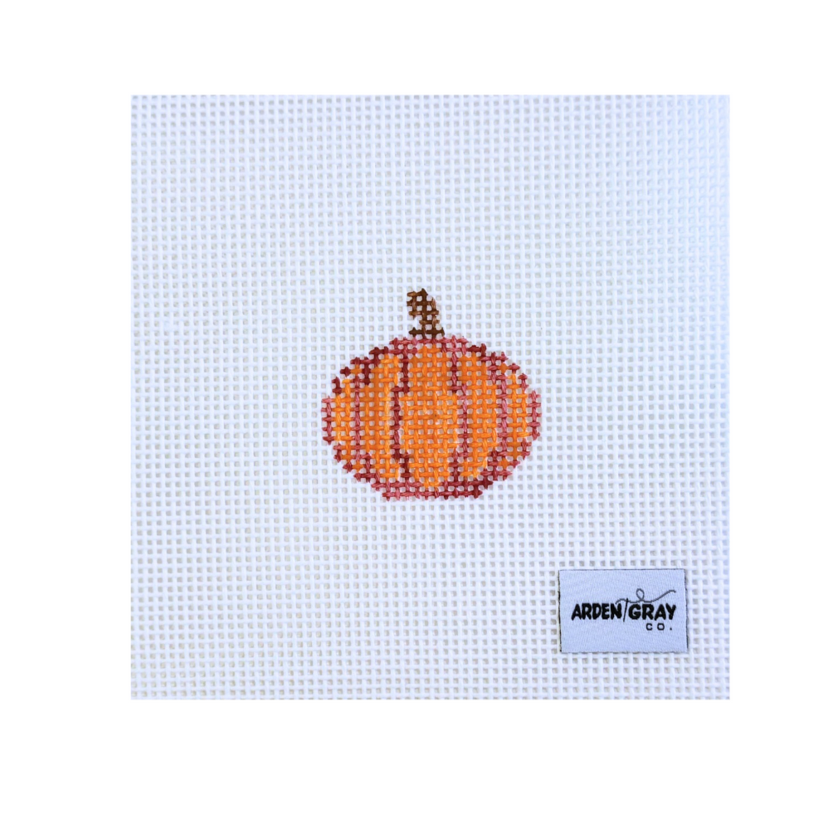 A square white needlepoint canvas featuring a stitched orange pumpkin design in the center and an Arden Gray brand label in the lower right corner.