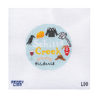 A square cross-stitch design on white Aida fabric, featuring a circular light blue patch with the words 'Snipitit Creek' in yellow, surrounded by small embroidered icons in black, red, orange, brown, and white. The bottom of the fabric shows the text 'PERRY CANN' on the left and 'LDD' on the right.