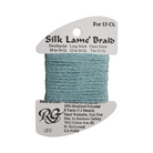 A spool of Silk Lame' Braid needlepoint thread in a dusty teal blue color, mounted on a white cardboard hanger with product details printed on the sides.