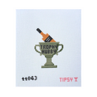 A needlepoint canvas featuring a pixelated trophy cup with a champagne bottle inside, the words 'TROPHY HUBEN' on the cup, and small red/pink text reading 'TIPS4Y' and 't0043' on a white grid background.